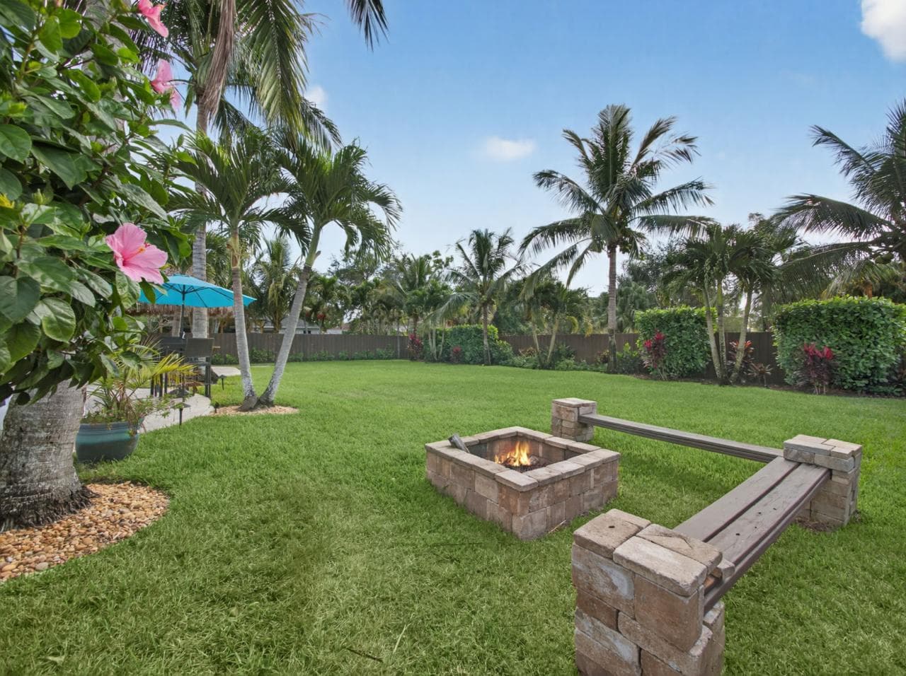 Fire pit with stone benches and tropical landscaping