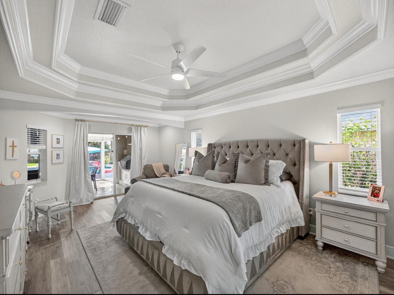 Master bedroom with tray ceiling and pool-view doors